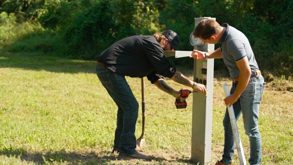 Two EW employees repairing a pedestal